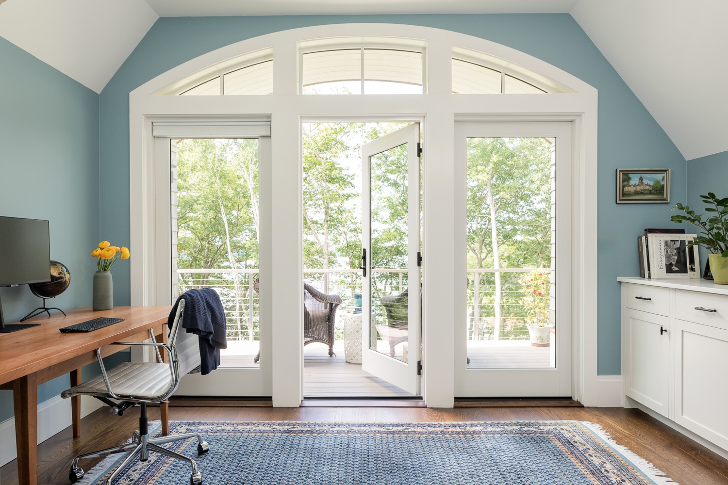 The upstairs office and private gathering area has its own balcony which looks out over casco bay. The arched windows are carried through and reflected in an arched roof.