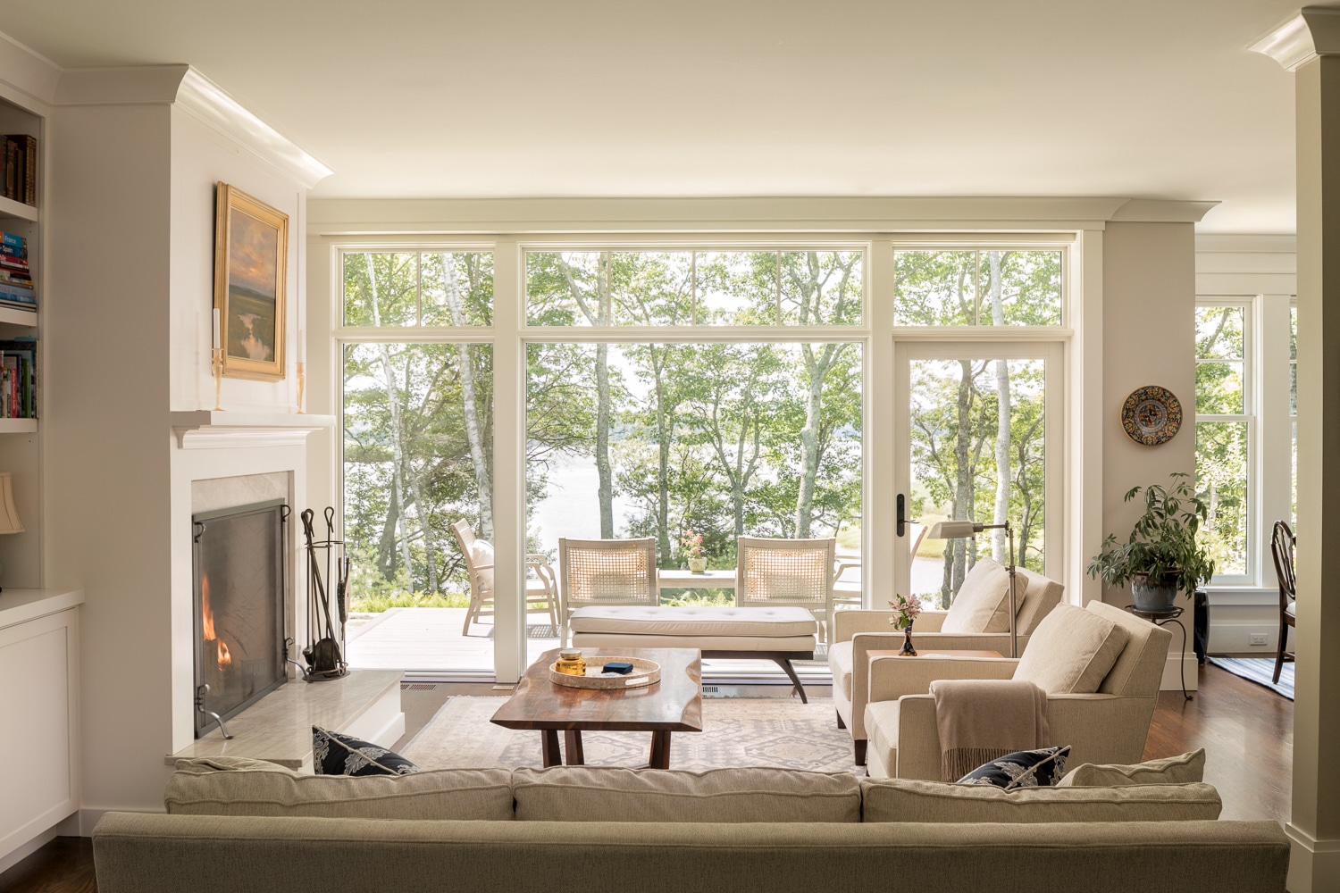 While the fireplace forms the center of the dinning room the commanding view is that of outside with a patio area, trees and then Casco Bay.
