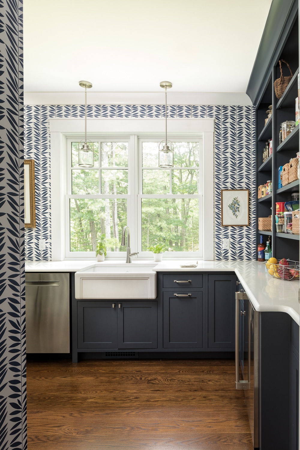 The pantry/ prep area off the kitchen looks out over the woods, the contrasting wallpaper on the walls draws you in