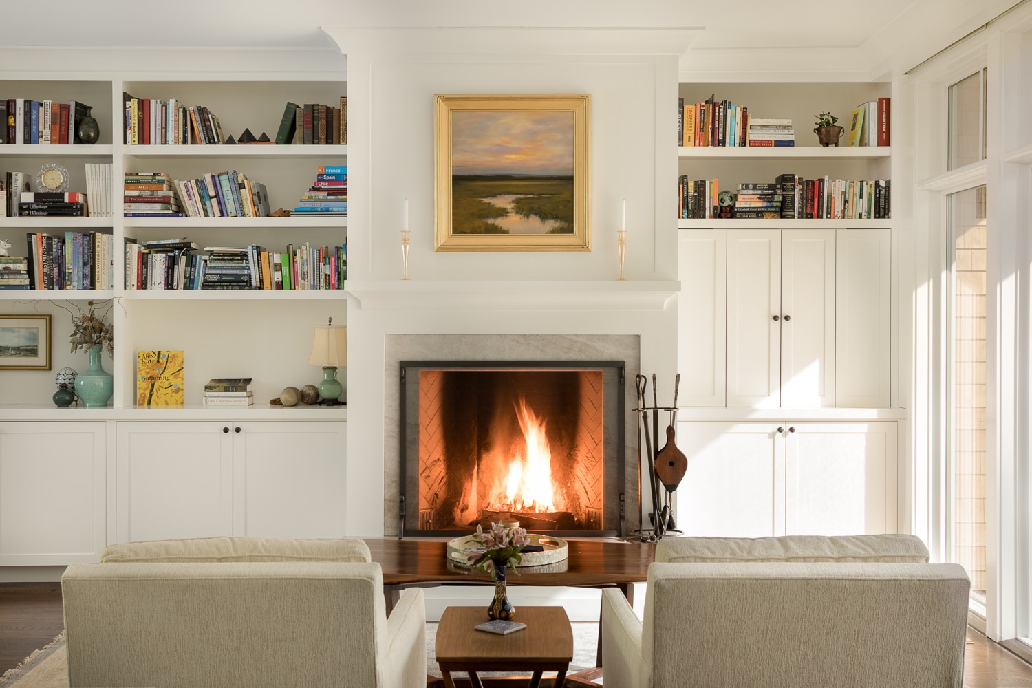 Fireplace in living room is flanked on each side by custom built-in book selves and storage.