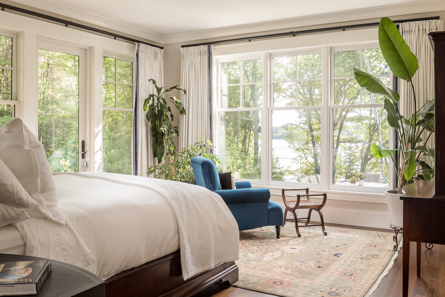 Large windows offer views through the trees of Casco Bay, Maine.