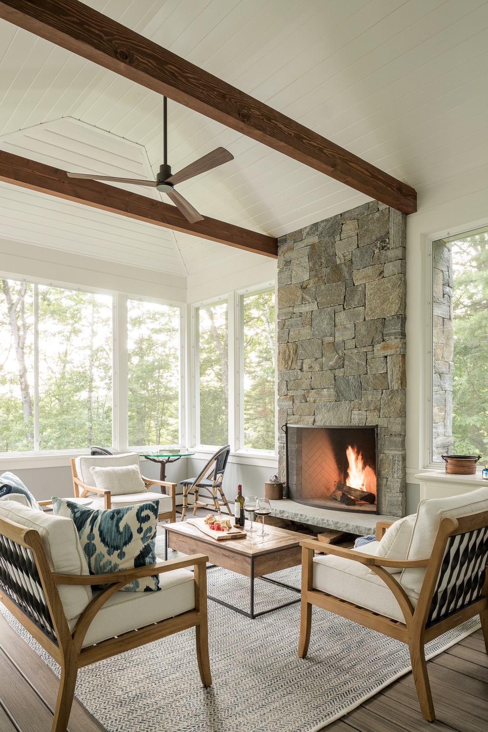Screened in porch with a stone fireplace.
