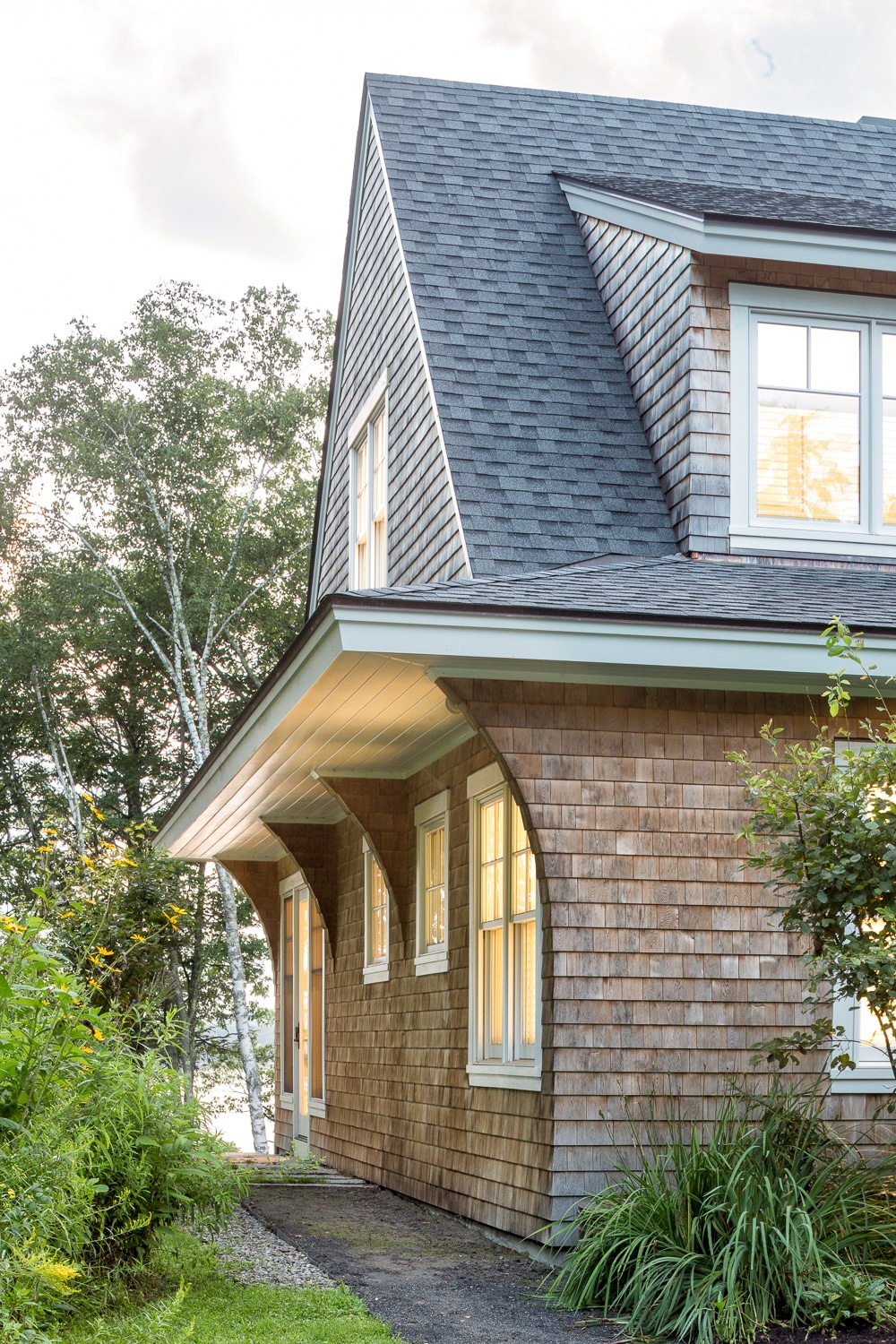 Surrounded by nature this is a classic New England cedar shake style house with a twist.