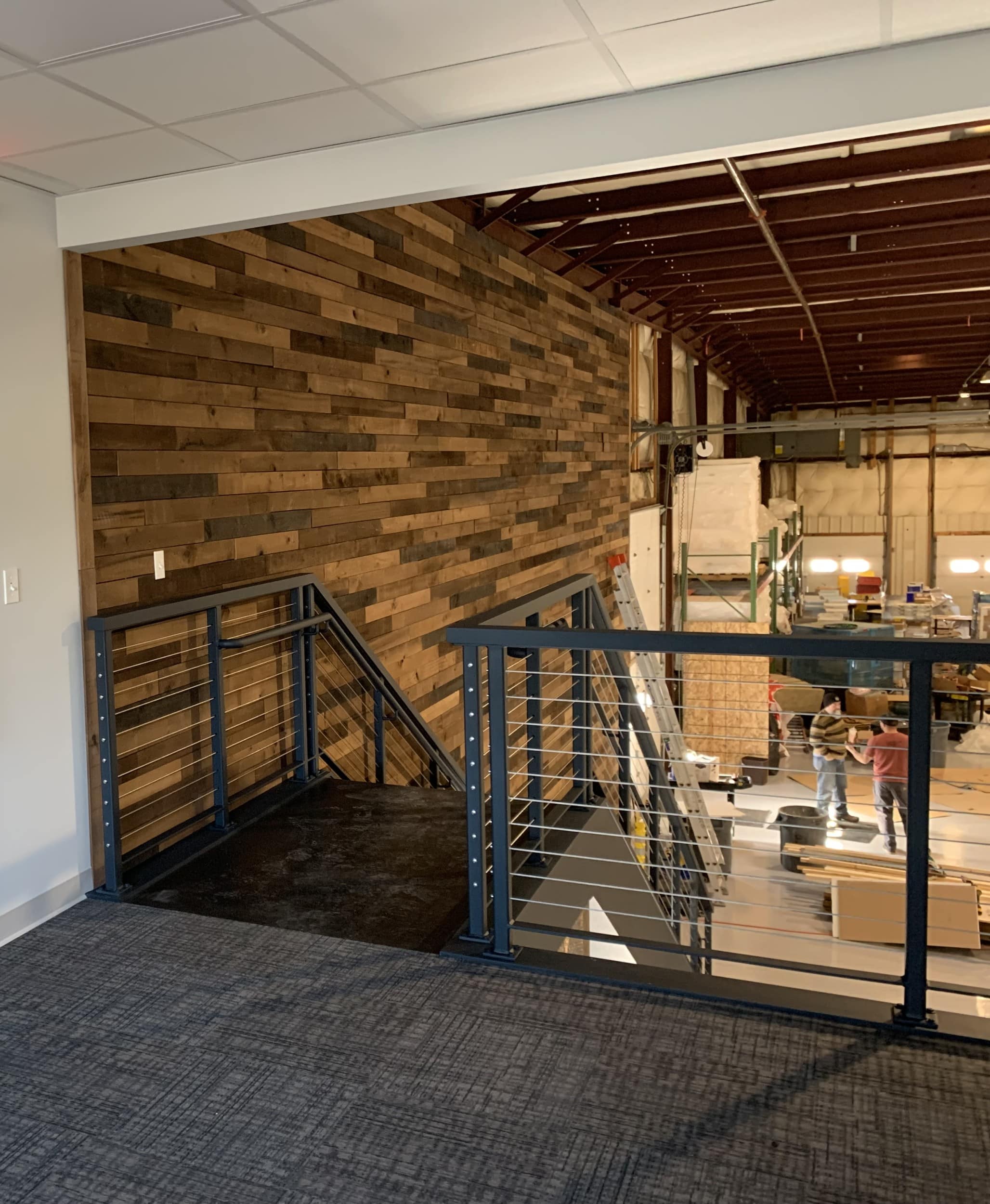 Stairs leading down from mezzanine into warehouse.