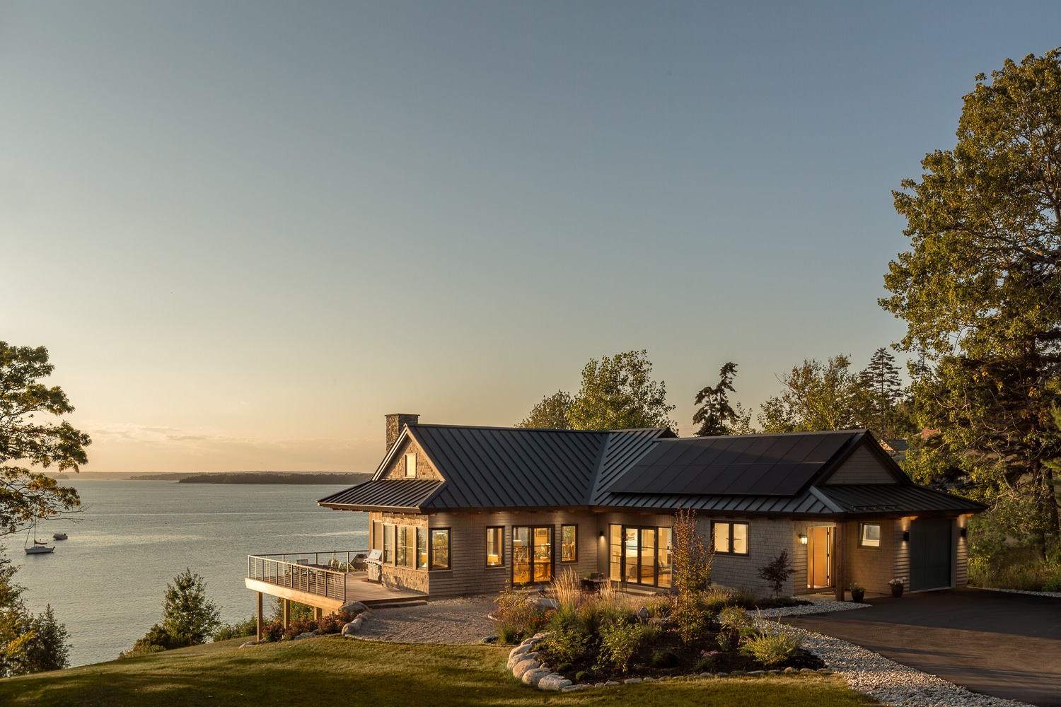 Custom built house overlooking the Maine coast with a large wrap around deck built by Warren Construction Group.
