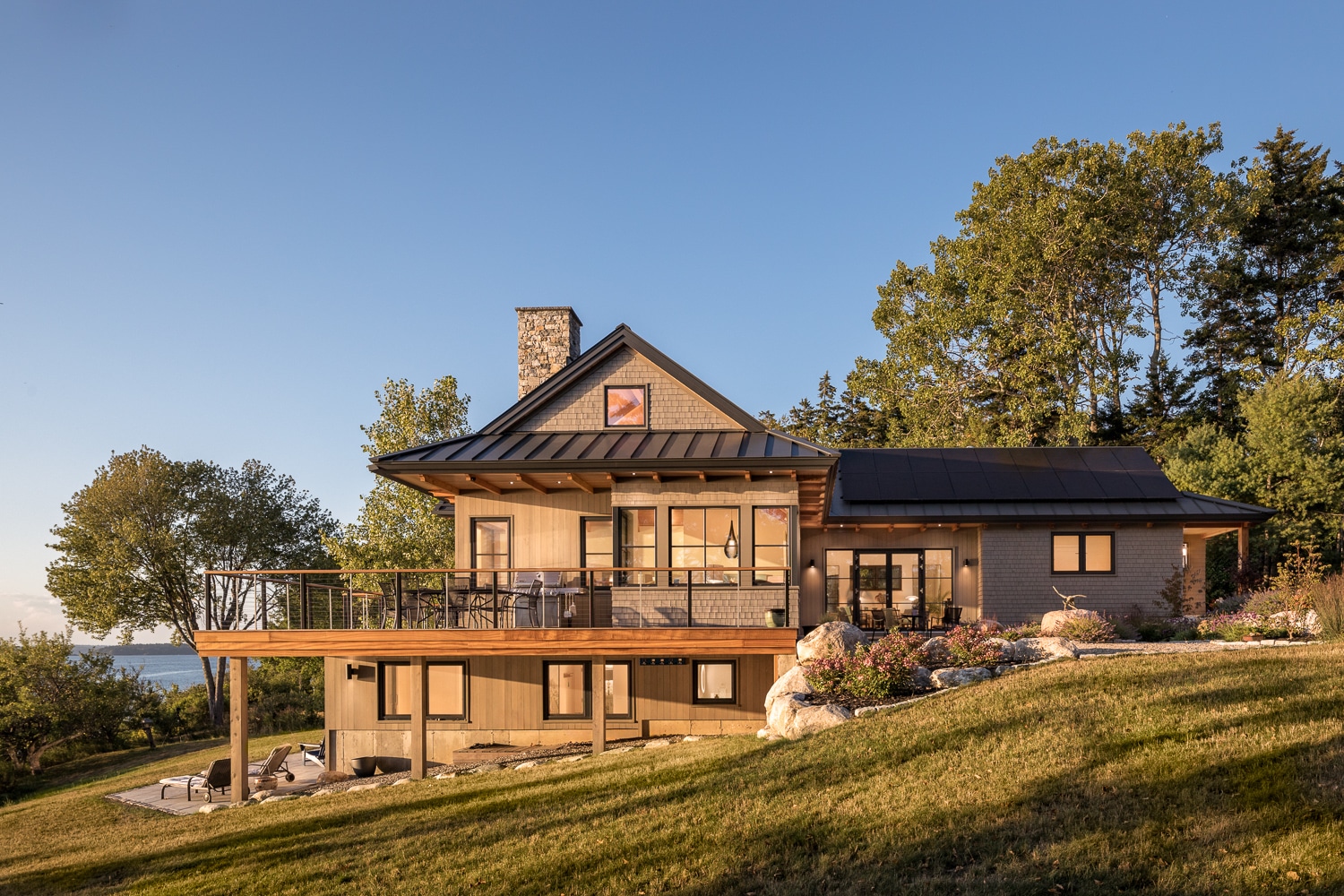 Evening light on a coastal house built in Harpswell Maine. A custom build by Warren Construction Group