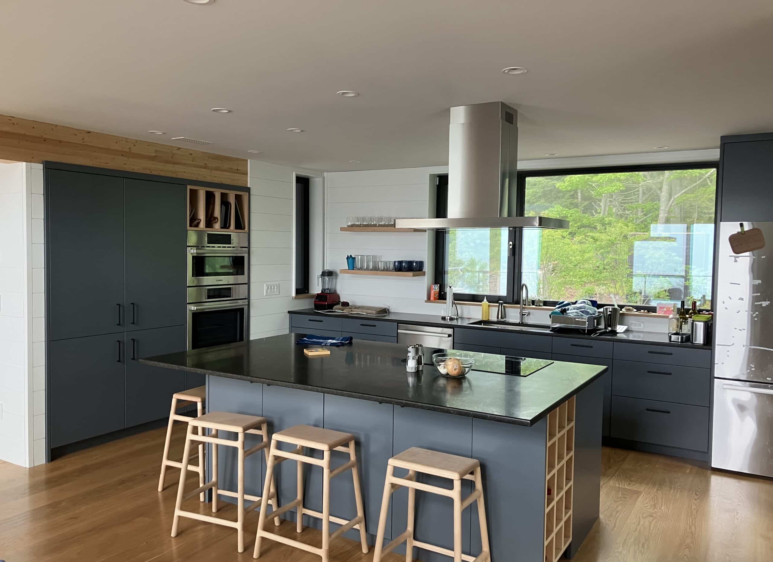 Custom Built kitchen by Warren Construction Group with island cook top and suspended fan.