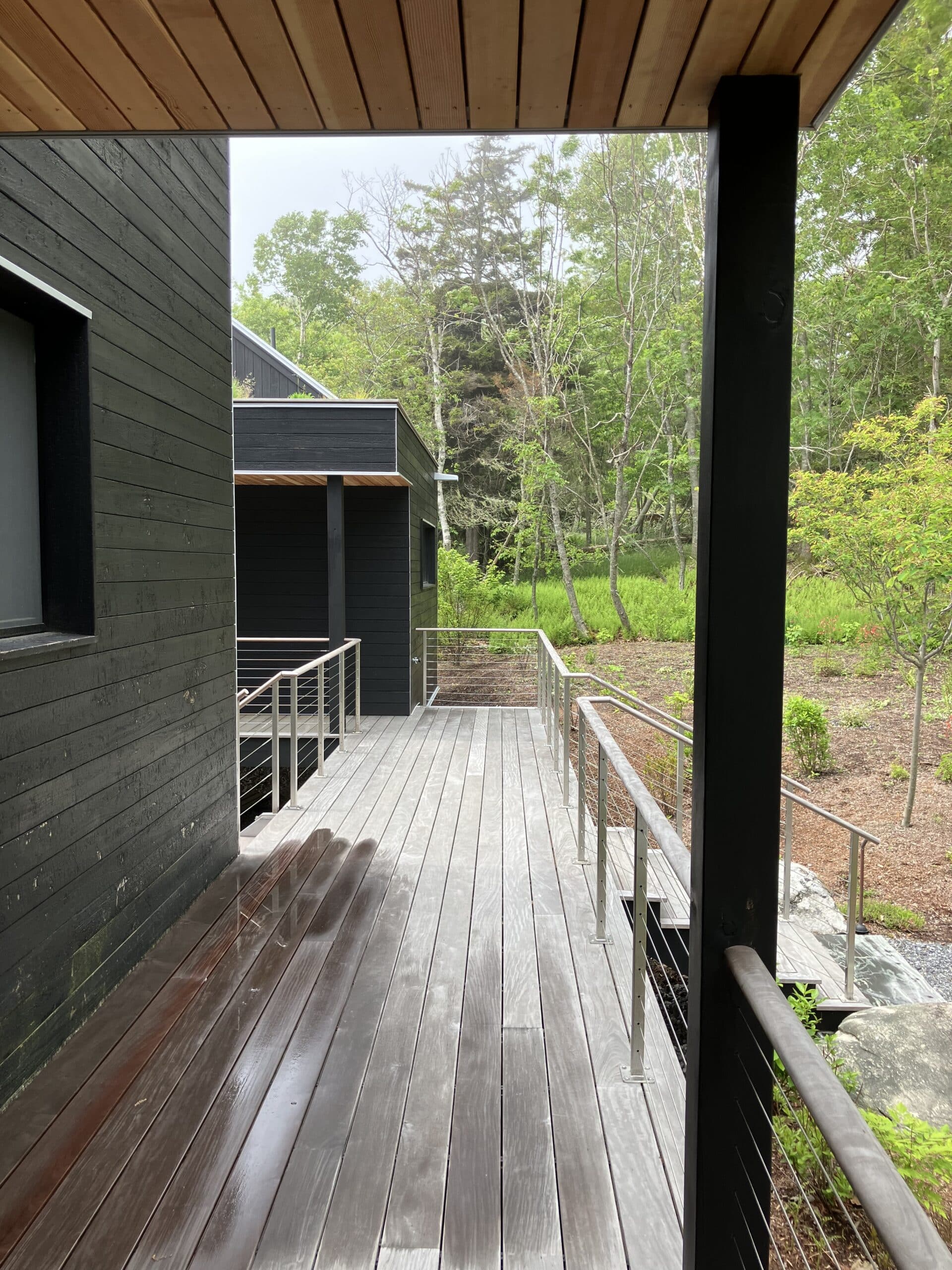 Walkway deck between the house and guest house on this custom Bensonwood house in Maine.