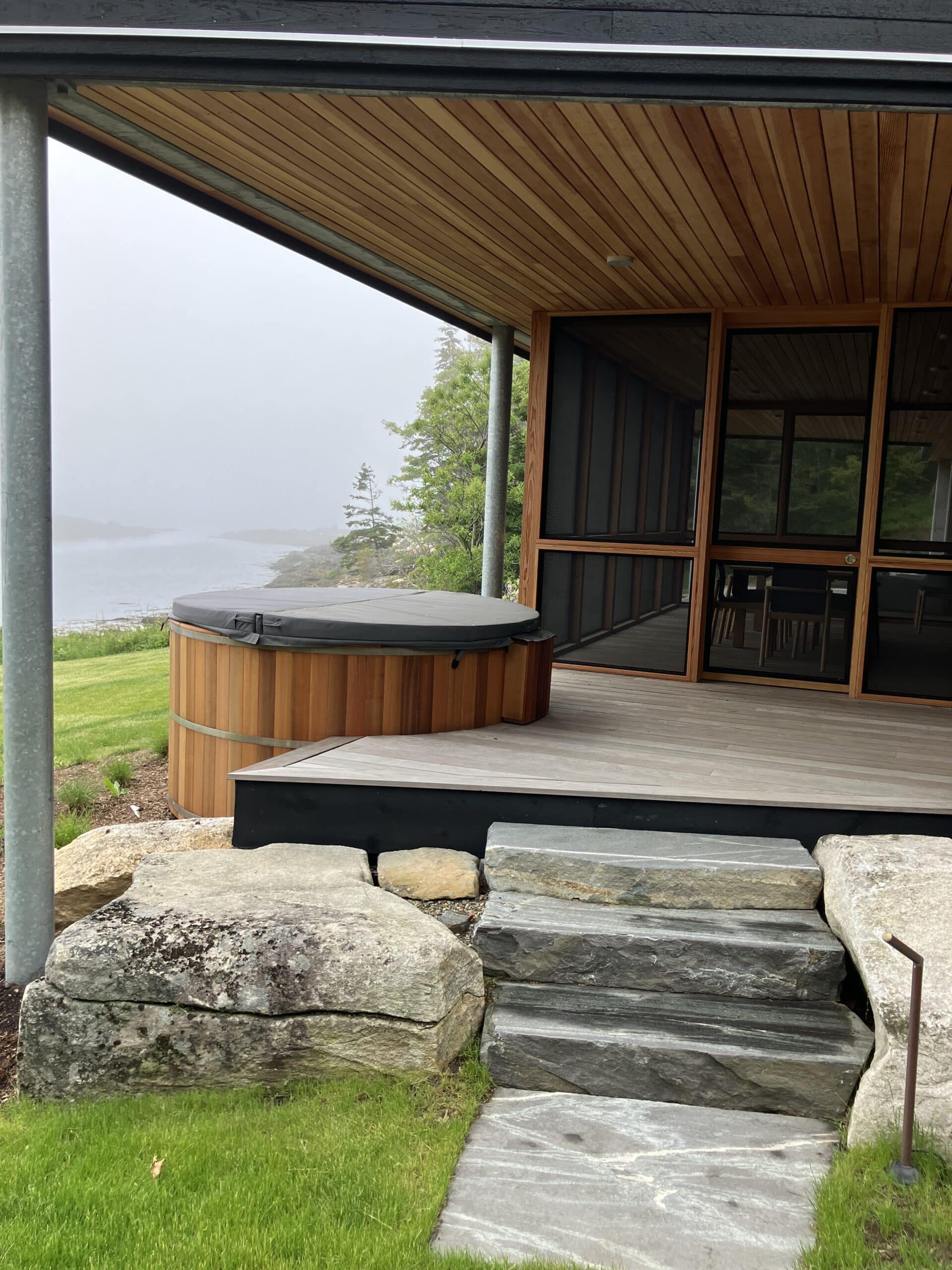 Screened in porch with hot tub overlooking the ocean in Maine.