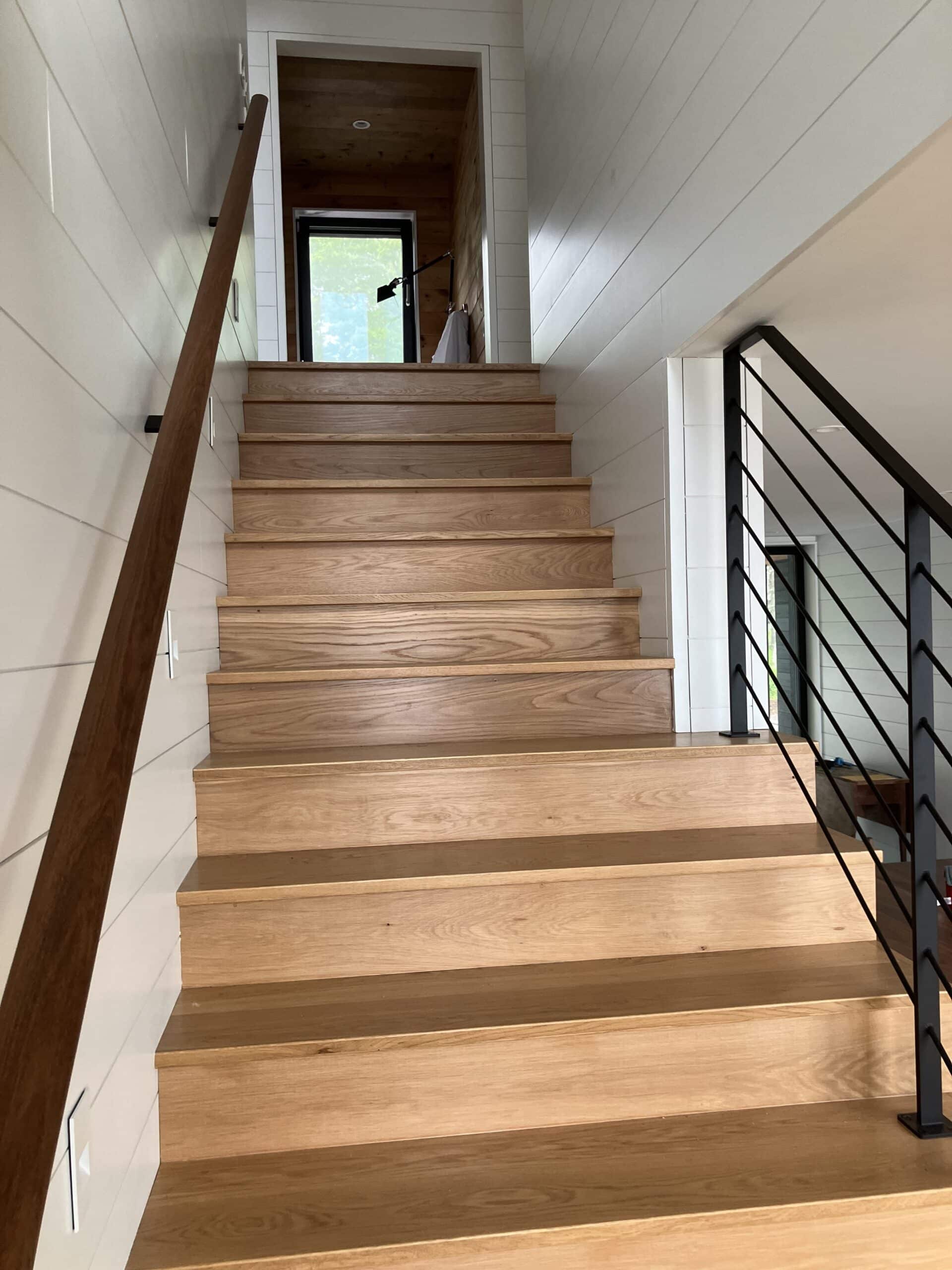 Stairs leading to the second floor of a custom Bensonwood panelized house on the coast of Maine.