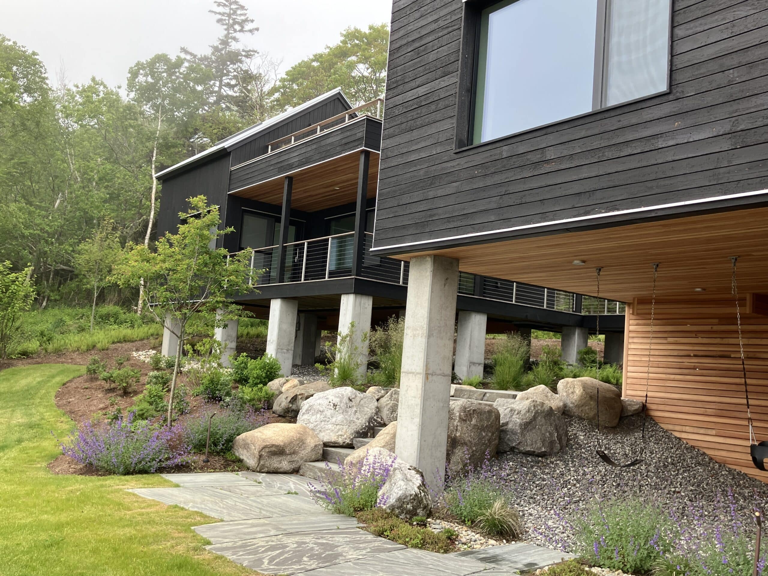 Bensonwood panelized house built on concrete piers to raise it above the flood plain on the coast of Maine